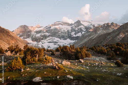Tajikistan. Fann mountains Summer. Sunset. Snowy mountains are reflected in the lake.