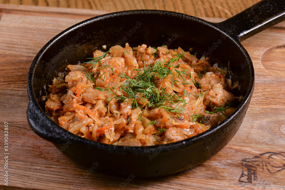 Vegetable and meat stew served in a pan over rustic wooden background table. Ukranian Traditional cuisine. Vegetable and meat stew served in a pan over rustic wooden background table. Ukranian Traditional cuisine.