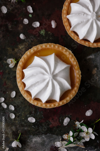 lemon cheesecake pie on wooden background with flower petals