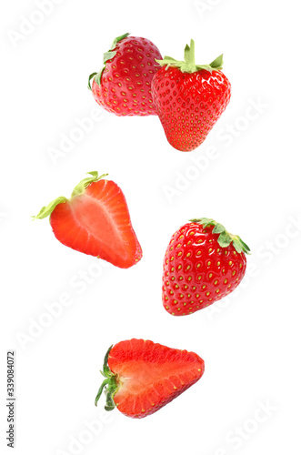 Set with falling sweet strawberries on white background