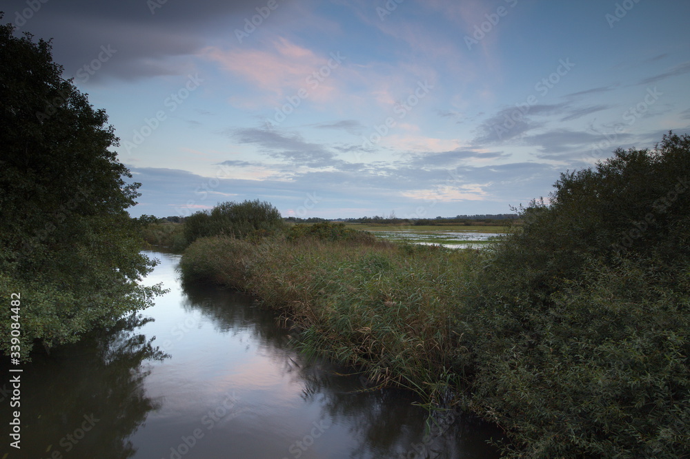 Meadows and river in the evening, at sunset time