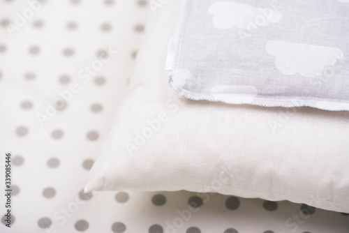 white pillow and the cover lie on the white at the point of the sheet in the children 's roof. soft bed. photo