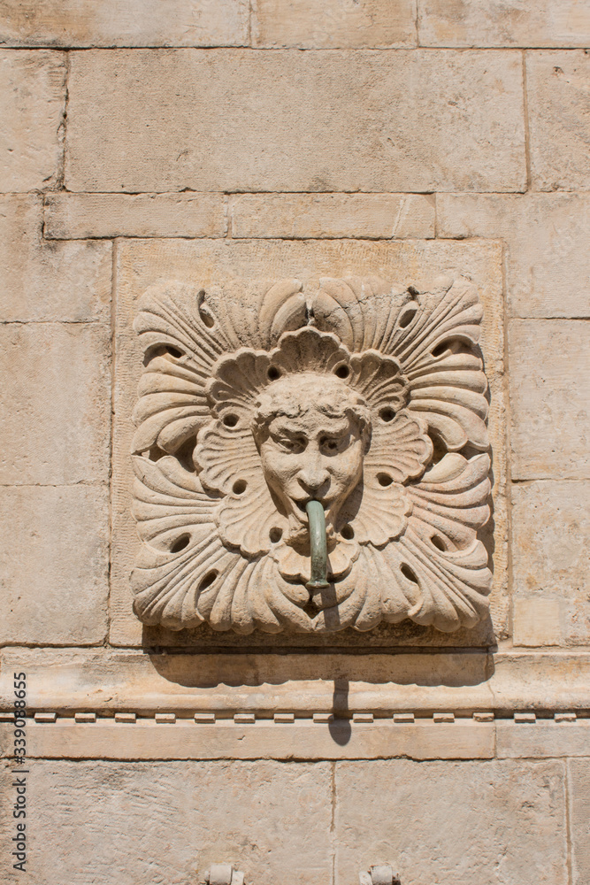 Amazing Onophrian Fountain gargoyle with water spout from the mouth the old town of Dubrovnik Croatia Water flowing down