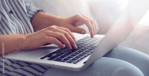 Young woman working on computer indoors, closeup. Banner design