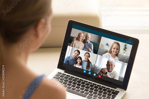 View over girl shoulder, use webcam and laptop enjoy distant communication with family. Diverse relatives people chatting via videoconference application modern technology for make life easier concept