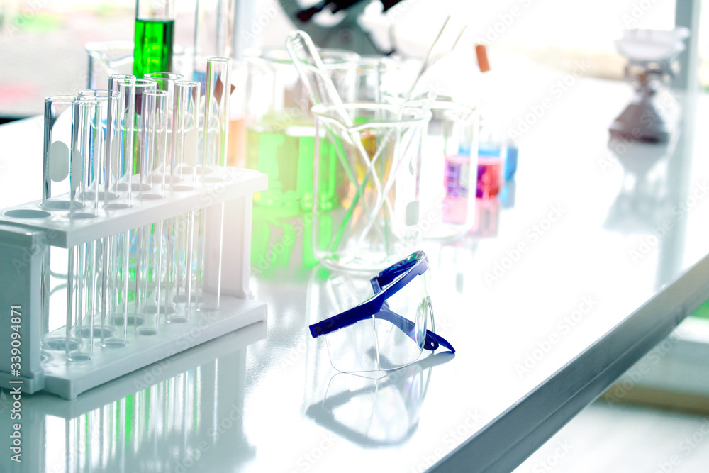 Safety glasses goggles and scientific glassware for doing science experiment, biology and chemistry lab, laboratory research concept Safety glasses goggles and scientific glassware for doing science experiment, biology and chemistry lab, laboratory research concept