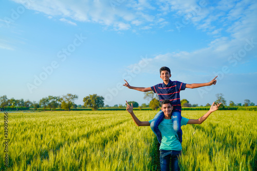Brother piggyback his little brother in wheat field  rural india