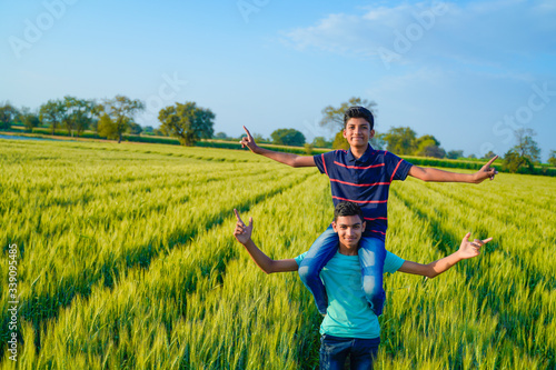 Brother piggyback his little brother in wheat field  rural india