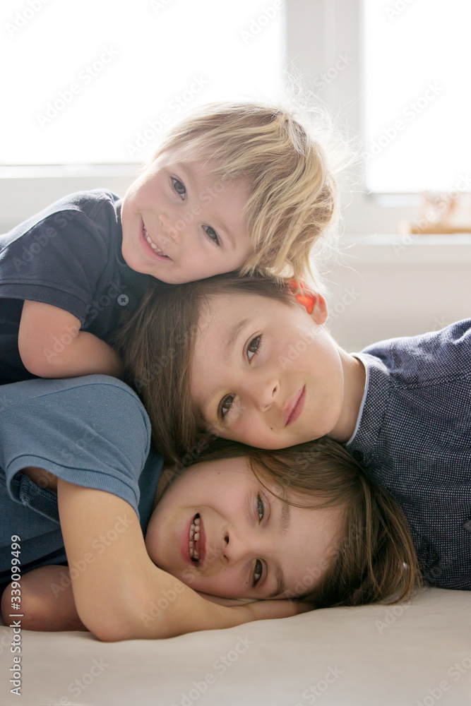 Three beautiful children, boy brothers, having family portrait, hugging Three beautiful children, boy brothers, having family portrait, hugging