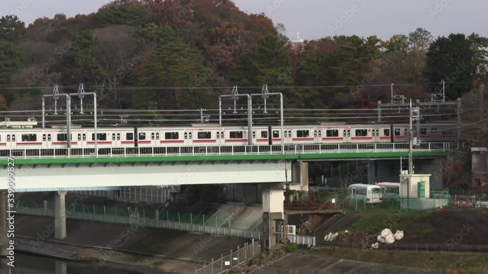 Trains Passing On The Railroad Bridge Over The Calm River In Tokyo, Japan.-wide shot Trains Passing On The Railroad Bridge Over The Calm River In Tokyo, Japan.-wide shot