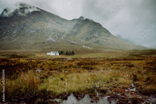 Obraz na płótnie Small white house on a meadow in the scottish Highlands. w salonie