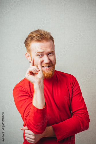 Konstfotografi Young hipster red bearded Man showing small amount gesture