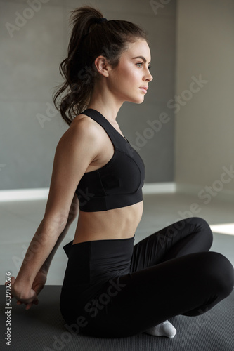 Fototapeta Naklejka Na Ścianę i Meble -  Photo of caucasian young woman stretching her arms while working out