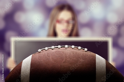 American football ball and woman on background