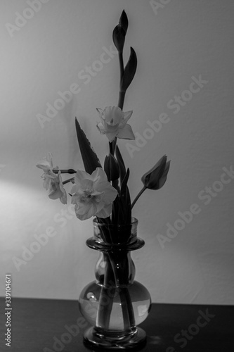 bunch of flowers in a vase illuminated by the light of a table lamp