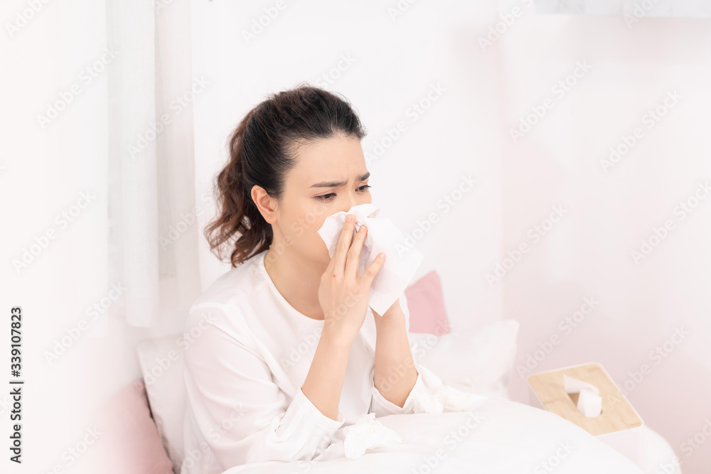 Sick woman covered with a blanket lying in bed with high fever and a flu, resting. Sick woman covered with a blanket lying in bed with high fever and a flu, resting.