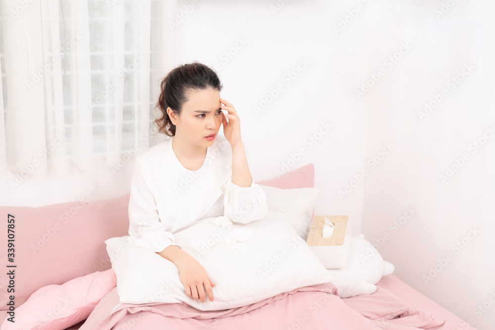 Flu. Closeup image of frustrated sick woman with red nose lying in bed in thick scarf Flu. Closeup image of frustrated sick woman with red nose lying in bed in thick scarf