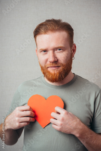 bearded man is happy and keeps the heart in the hands