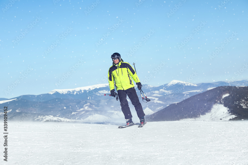 Male skier on snowy slope in mountains. Winter vacation Male skier on snowy slope in mountains. Winter vacation