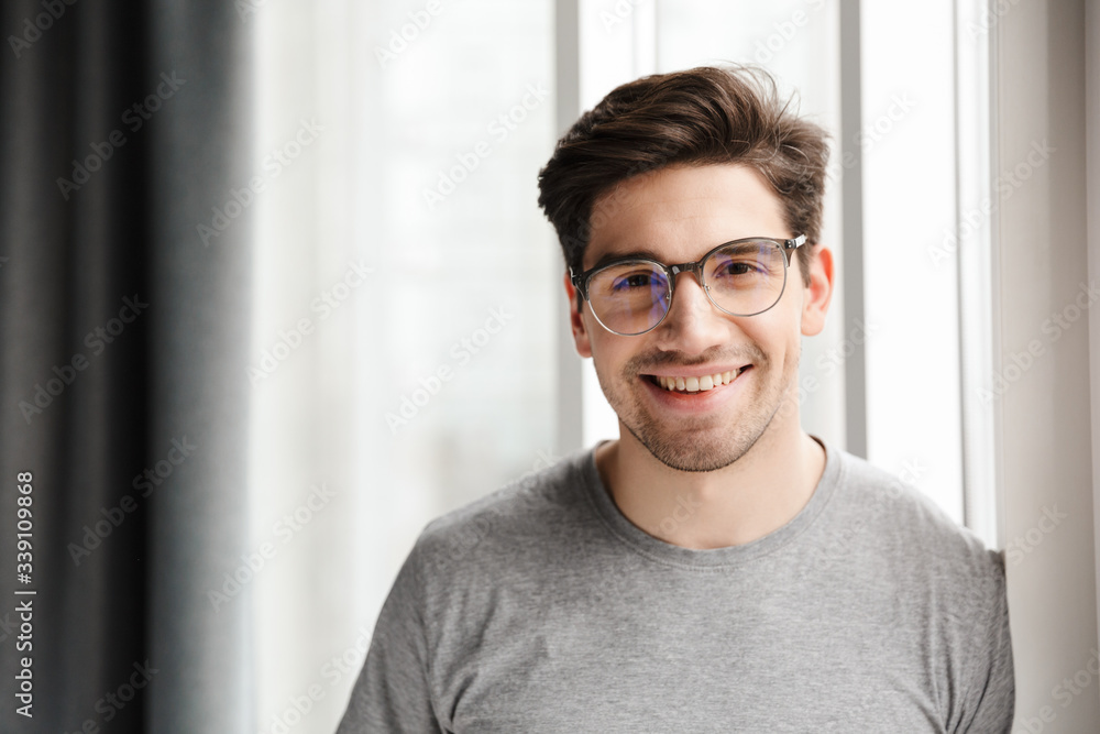 Fototapeta premium Smiling young man indoors at home looking camera.
