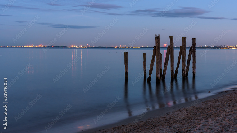 Fototapeta premium Wooden piles in the Gulf of Gdansk in Poland at dusk