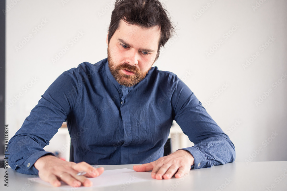 man writes on a piece of paper at the table man writes on a piece of paper at the table