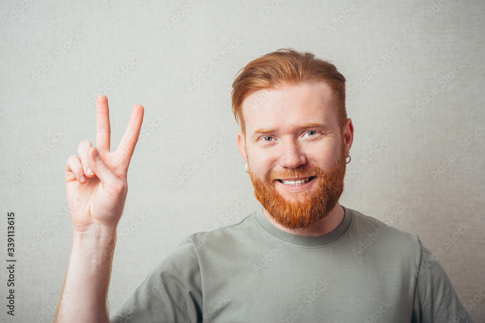 Young hipster red bearded man doing victory gesture Young hipster red bearded man doing victory gesture