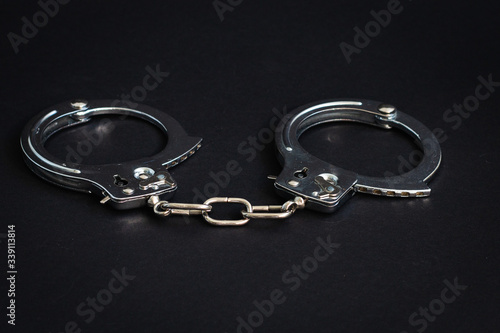 Handcuffs on a black background. Close-up. Police handcuffs. Criminal, corruption concept