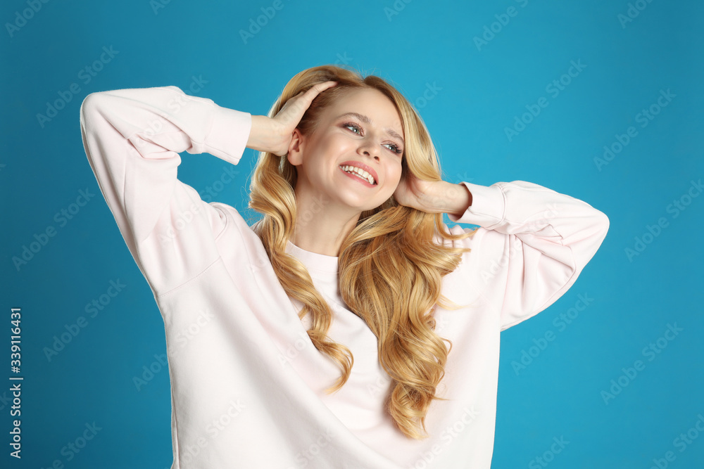 Portrait of beautiful young woman with dyed long hair on blue background Portrait of beautiful young woman with dyed long hair on blue background