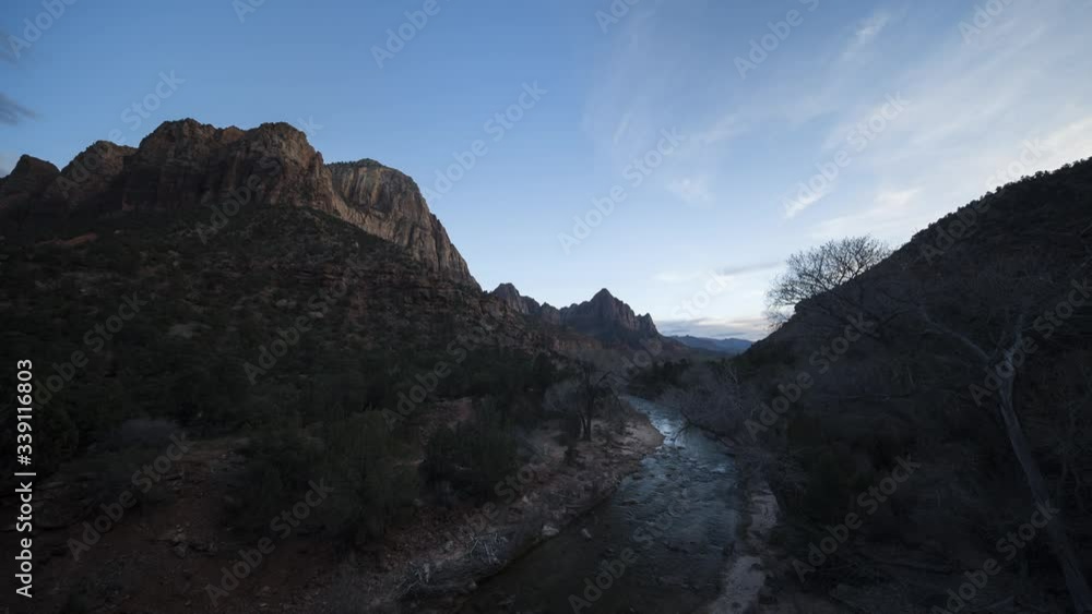 A stunning ultra-wide sunset timelapse of multi-level cloud rolling overhead the Virgin River in Zion National Park. The sun’s light illuminates Bridge Mountain, the Watchmen and Joshua Mountain A stunning ultra-wide sunset timelapse of multi-level cloud rolling overhead the Virgin River in Zion National Park. The sun’s light illuminates Bridge Mountain, the Watchmen and Joshua Mountain