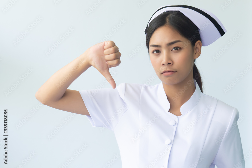 portrait of smiling asian woman nurse isolated, angry and upset female nurse or medical worker pointing thumb down hand sign for rejection, bad, problem not ok portrait of smiling asian woman nurse isolated, angry and upset female nurse or medical worker pointing thumb down hand sign for rejection, bad, problem not ok