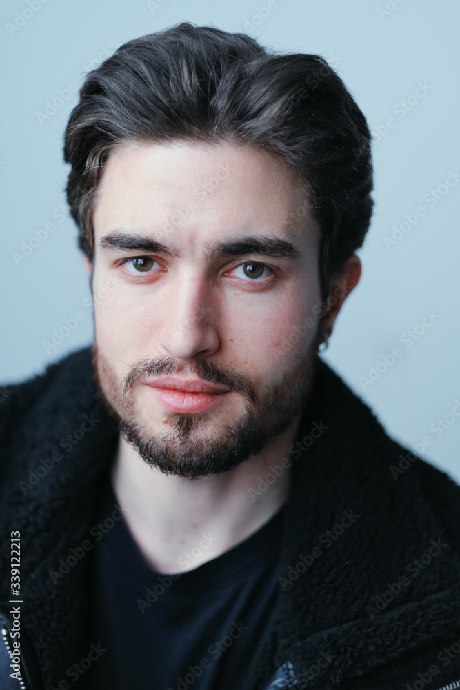 A large portrait of a stylish young man with a beard and dark hair in a black leather jacket A large portrait of a stylish young man with a beard and dark hair in a black leather jacket