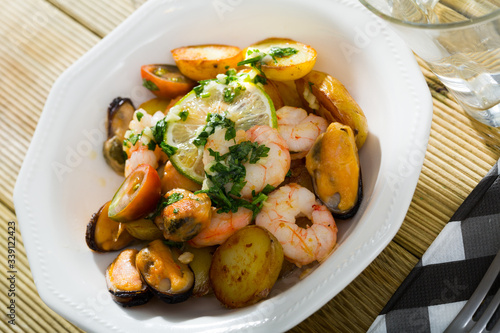 Delicious warm salad of shrimps, mussels and fried new potatoes