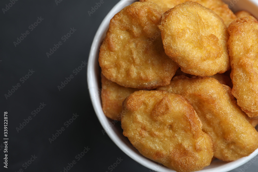 Bucket with tasty chicken nuggets on black table, top view Bucket with tasty chicken nuggets on black table, top view