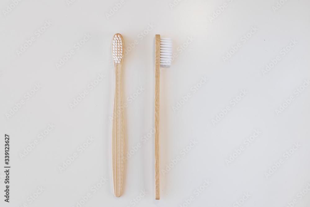 View of bamboo toothbrush front and side. Horizontal orientation. Dental zero waste and no plastic concept. Copy space, top view. Natural organic white brush. Isolated on white background. View of bamboo toothbrush front and side. Horizontal orientation. Dental zero waste and no plastic concept. Copy space, top view. Natural organic white brush. Isolated on white background.