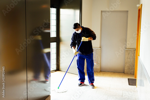 coronavirus. cleaning staff disinfecting the floor with bleach to avoid the spread of the virus photo