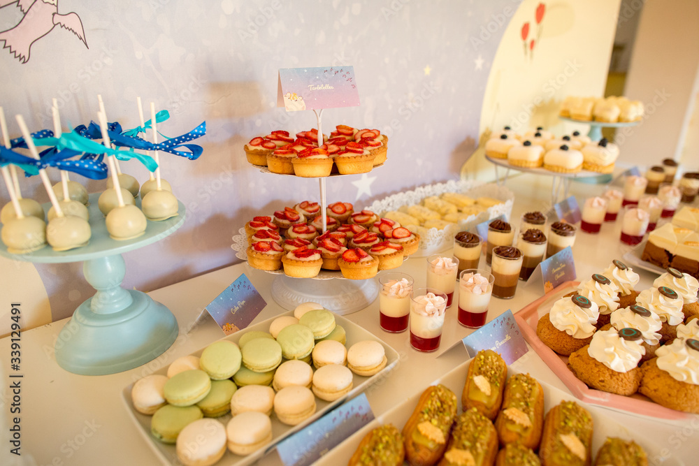 Naklejka premium Delicious colored candy bar with cupcakes, macaroons, cake pops and other sweets