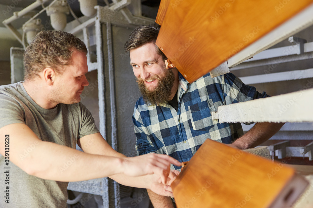 Two furniture makers discuss a workpiece Two furniture makers discuss a workpiece