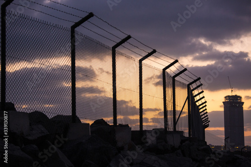 Fototapet Barbed Fence Sunset against Low Cloud 2of2
