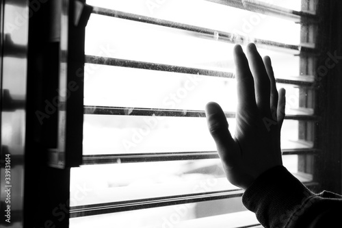 Hand touching  the window during confinment, quarentine by coronavirus. Looking out the window.