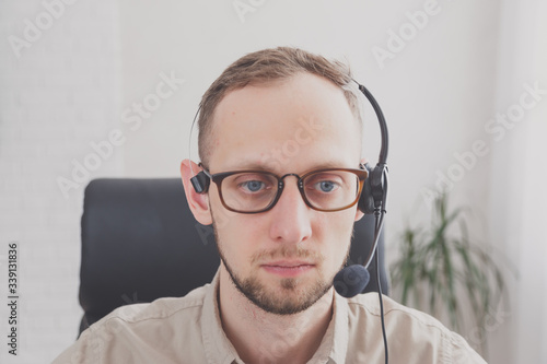 Young attractive man with a friendly smile wearing a headset for online communication as professional virtual client support or customer service © vladdeep