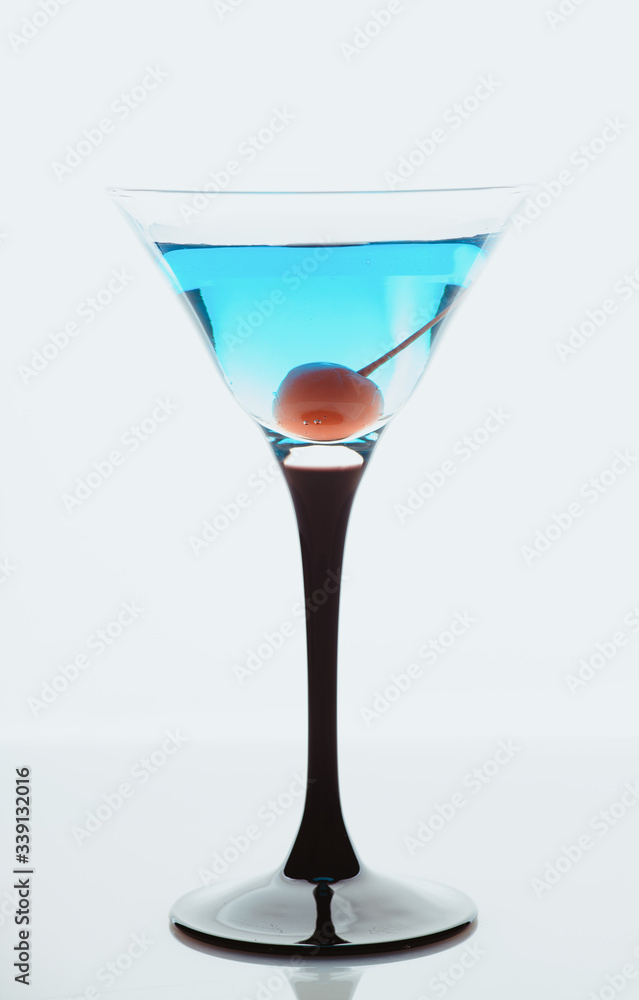 Blue martini cocktail with cherry on the rustic background. Selective focus. Shallow depth of field.