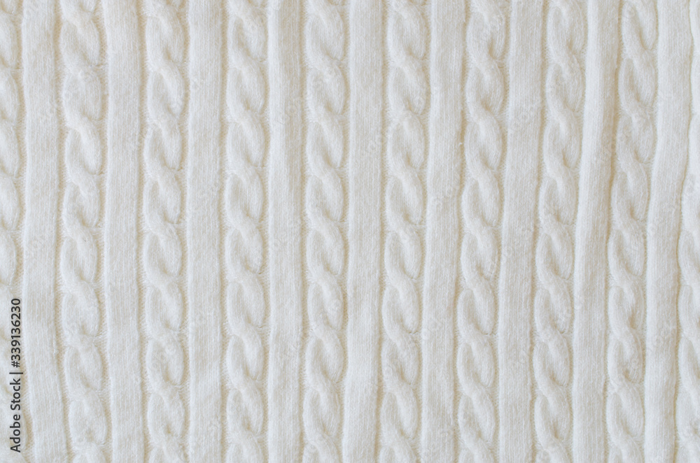 Beige knitted woolen background. Knitwear fabric texture. Beige knitted woolen background. Knitwear fabric texture.