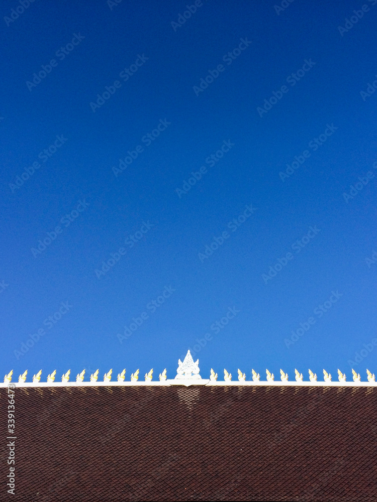 Temple roof tiles texture on clear blue sky background. Temple roof tiles texture on clear blue sky background.