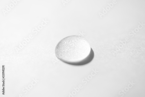 Tapet Close-up pure transparent water drop on white background, top view