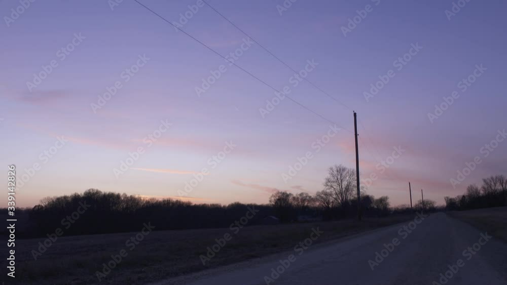 Purple Sunset On Rural Dirt Road With Power Lines Purple Sunset On Rural Dirt Road With Power Lines
