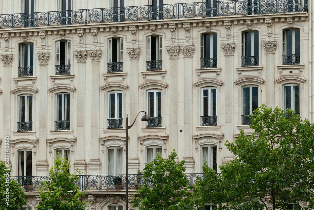 Typical old Paris architecture, facades of residential buildings with balconies and mansards, expensive real estate concept. City residents self isolation, deserted streets, european lifestyle