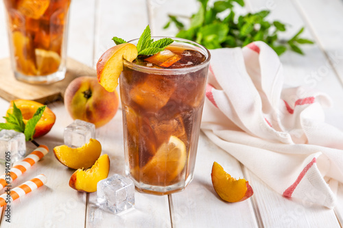 Iced tea and ingredients in glasses on wood background, copy space