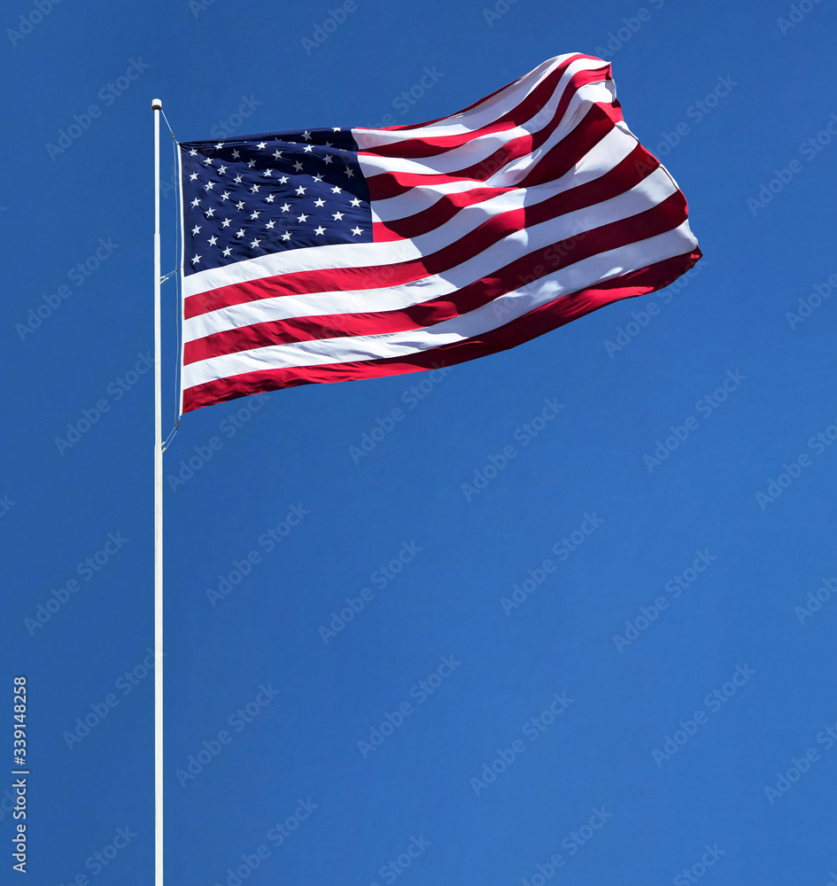 American flag on pole isolated on blue sky background including clipping path