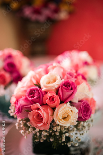 Brides maid s bouquets of pink and red roses  decorated with gold leafs and white flowers.
